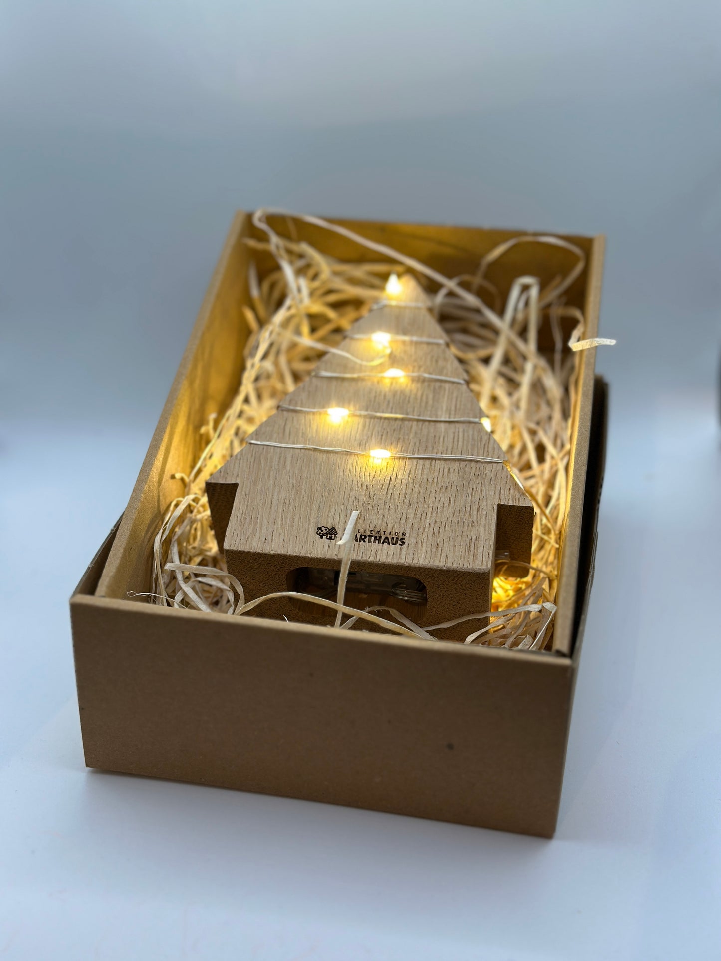 Engel und Tanne mit Beleuchtung in einer Geschenkbox
